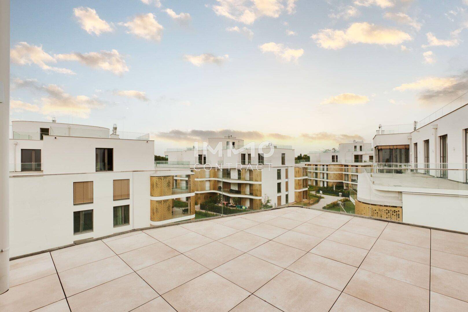 Weitläufige Dachterrasse mit moderner Architektur und Blick auf die Wohnanlage.