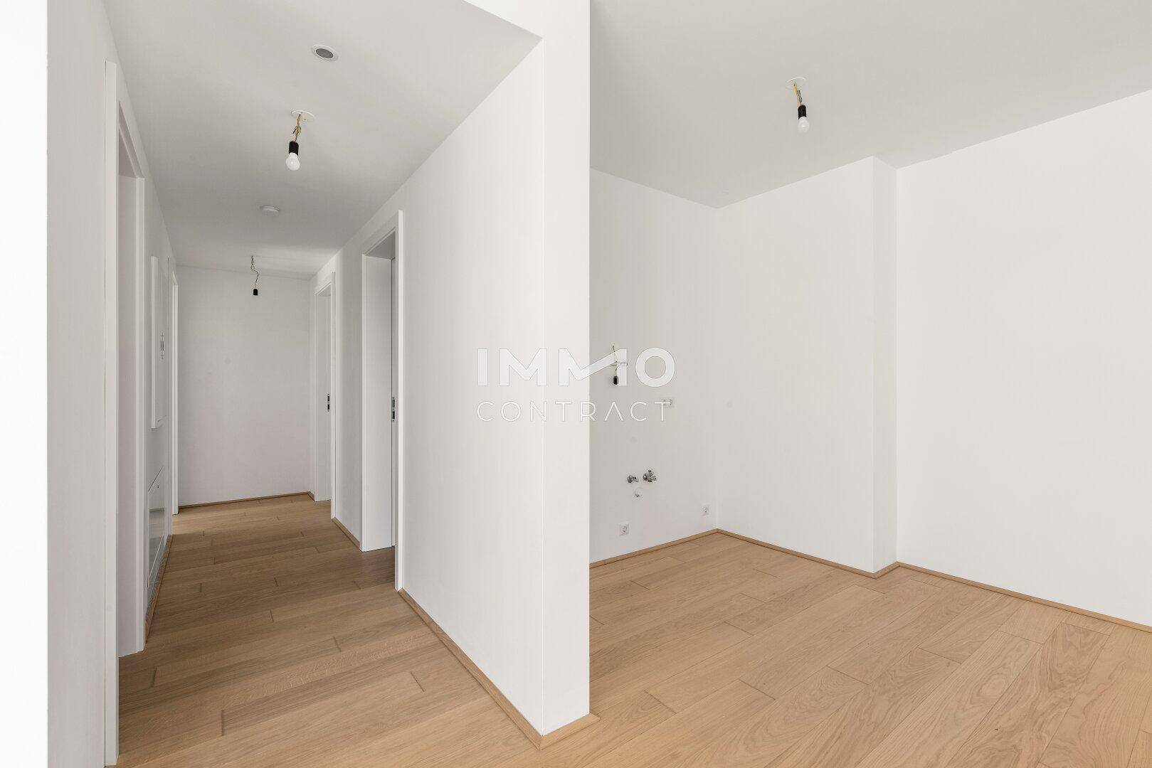 Heller Flur mit Holzparkettboden, der zu weiteren Räumen der Wohnung führt.