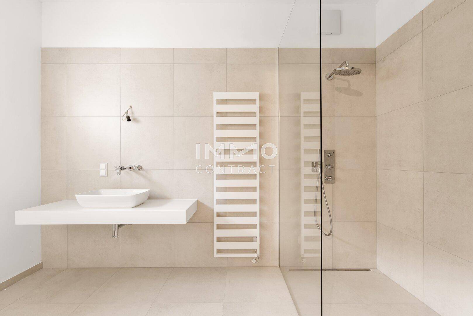Modernes Badezimmer mit begehbarer Dusche, Einzelwaschbecken und beheiztem Handtuchhalter.
