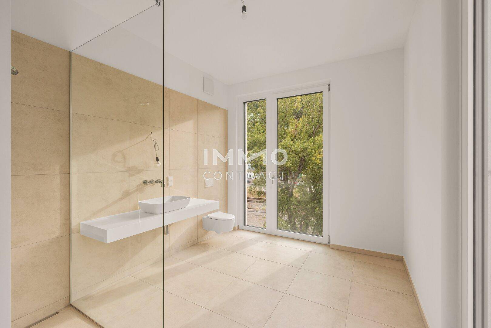 Modernes Badezimmer mit beigefarbenen Fliesen, schwebendem Waschtisch und großer begehbarer Dusche.