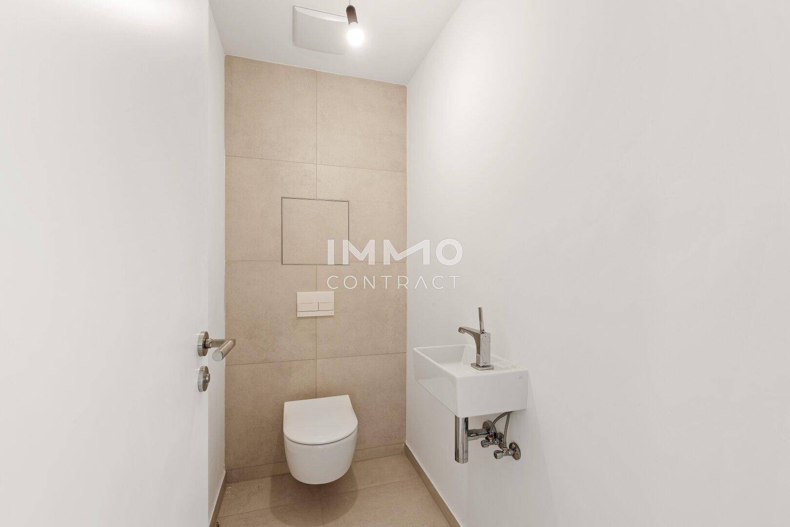 Modernes Gäste-WC mit wandhängender Toilette und kleinem Waschbecken in minimalistischem Design.