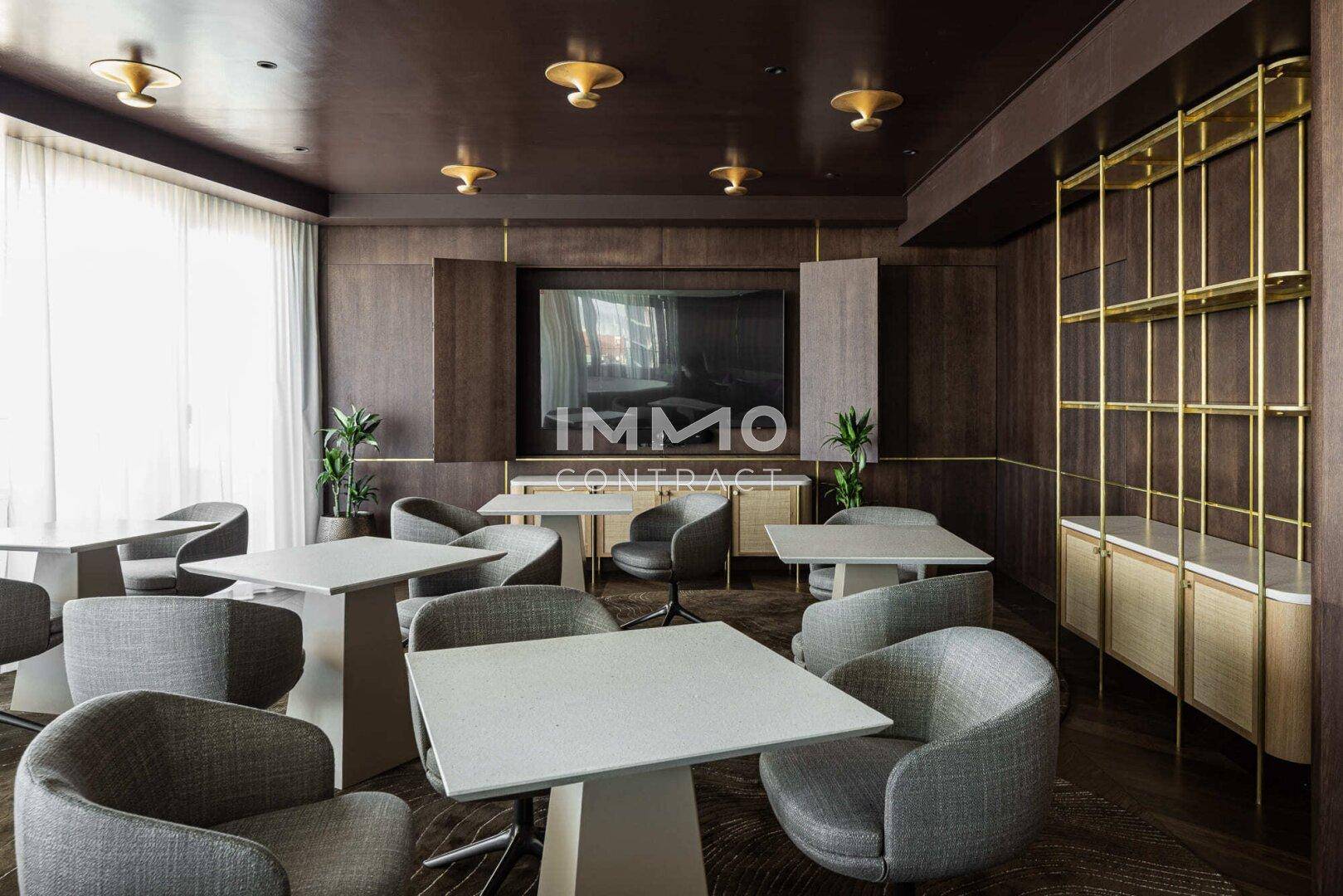 Gemütlicher Loungebereich mit bequemen Sesseln und Tischen, ideal für Besprechungen.