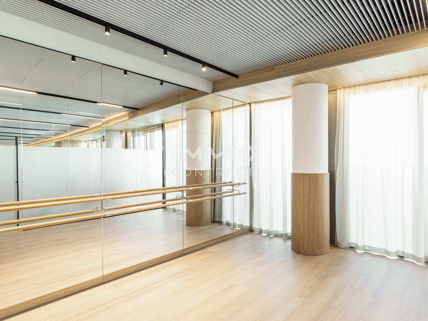 Heller Tanz- oder Yogaraum mit Spiegelwänden und Ballettstangen.