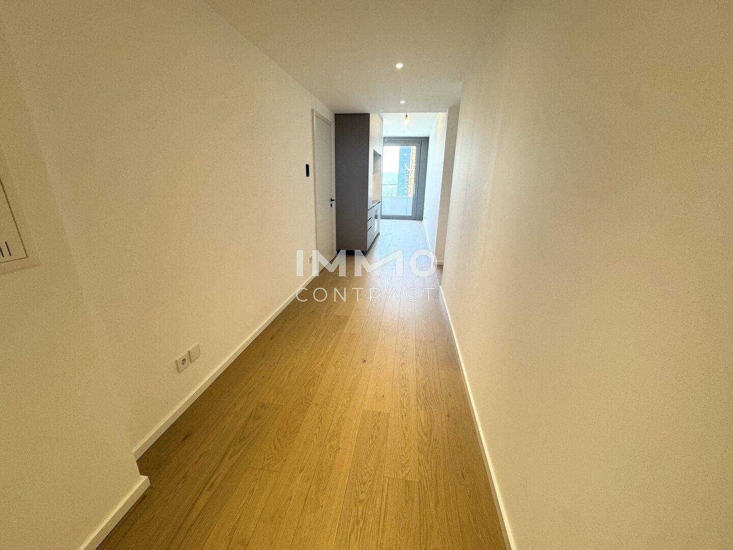 Heller Flur mit modernem Holzparkettboden und Zugang zu den Wohnbereichen.