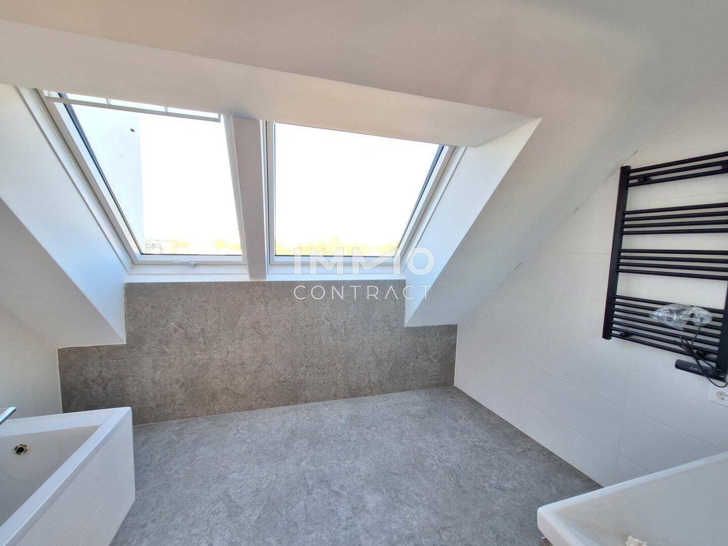 Modernes Badezimmer im Dachgeschoss mit Fliesenboden, Dachfenstern und beheiztem Handtuchhalter.