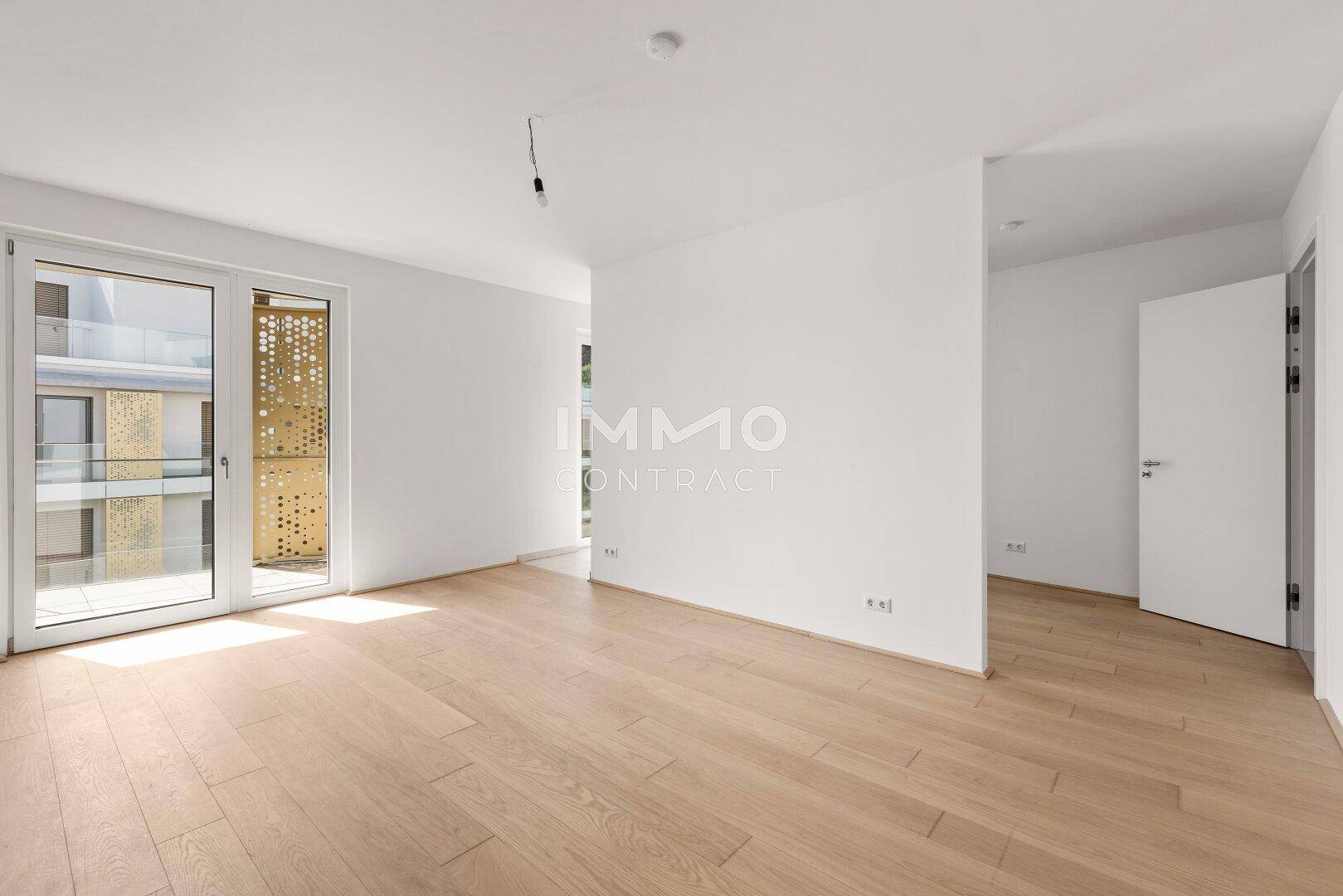 Helles Schlafzimmer mit Holzboden und Zugang zu einem Balkon, ideal für entspannte Stunden.