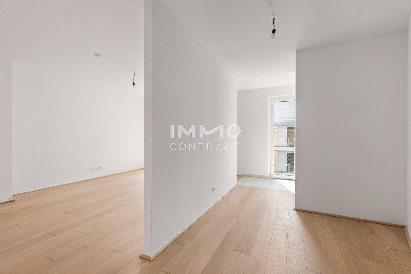 Heller Flurbereich mit Holzboden, der verschiedene Räume der Wohnung miteinander verbindet.