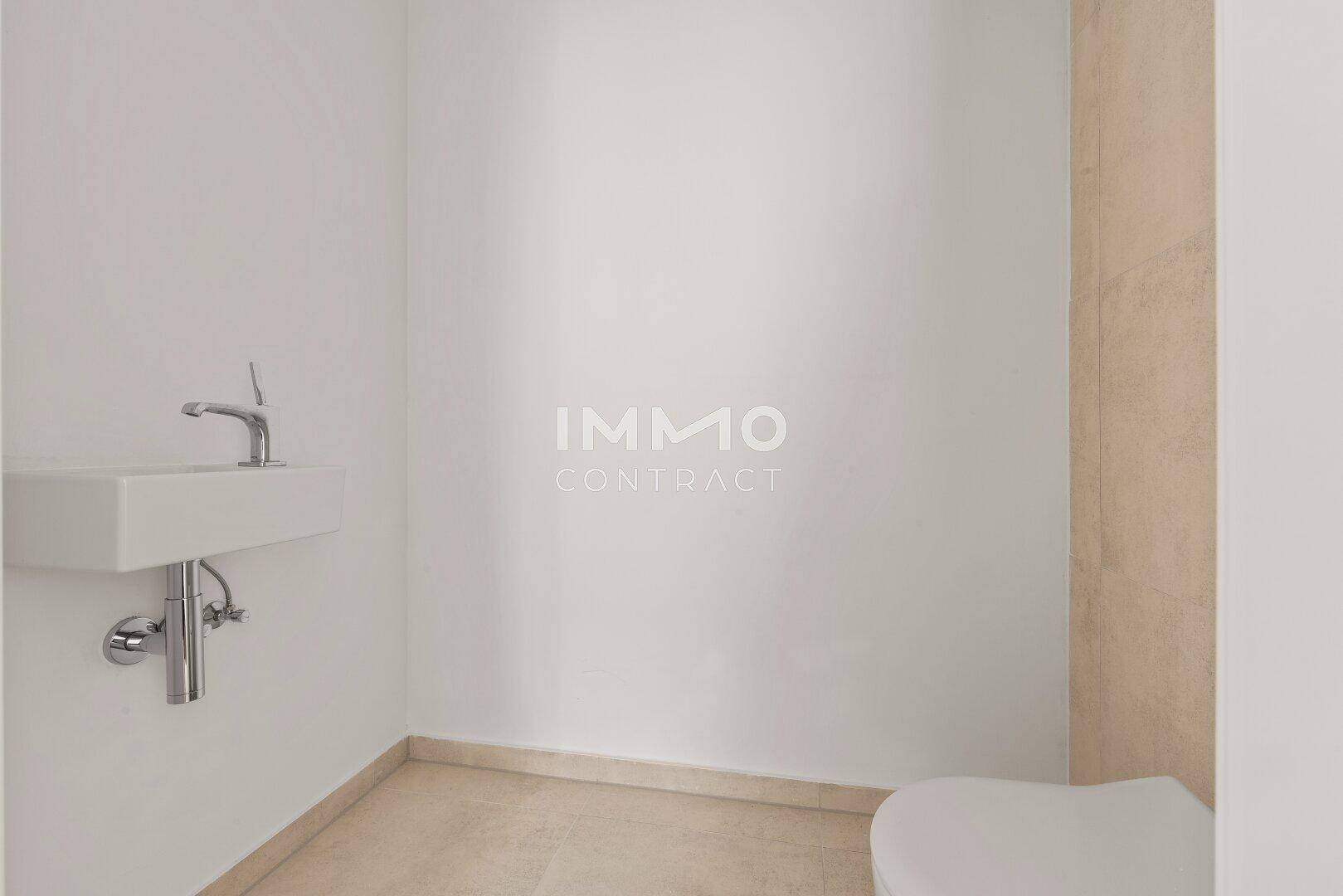 Modernes Gäste-WC mit Wand-WC und kleinem Waschbecken, ausgestattet mit hellen Fliesen.