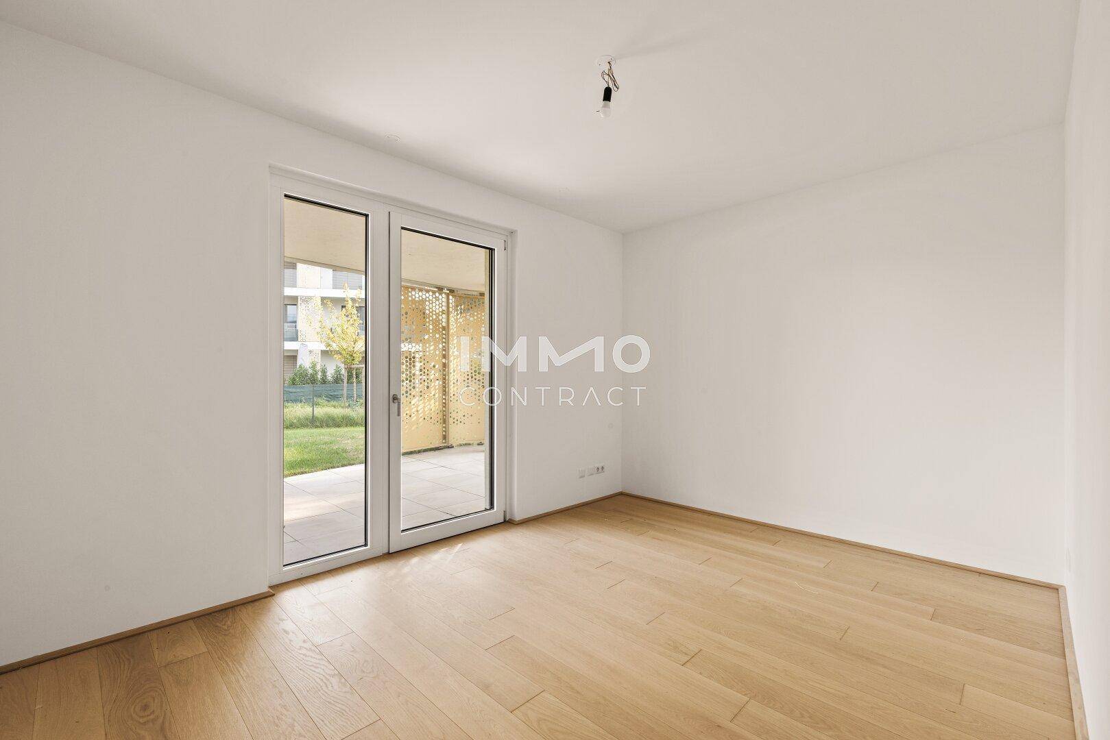 Helles Schlafzimmer mit Holzboden und direktem Zugang zu einem privaten Außenbereich.