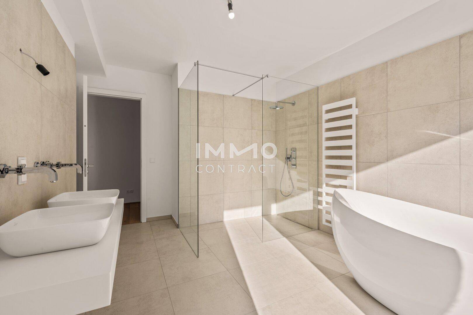 Modernes Badezimmer mit doppelten Waschbecken, freistehender Badewanne und großer Dusche.