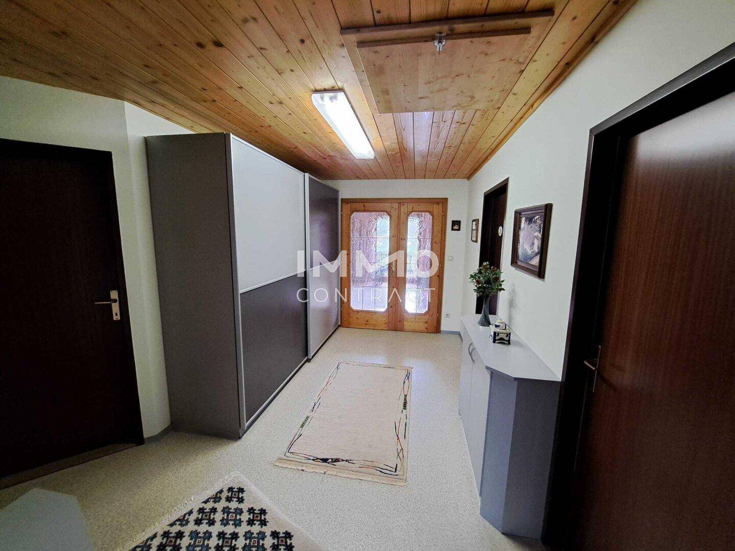 Eingangsbereich mit Holzdecke, Einbauschränken und Fliesenboden.