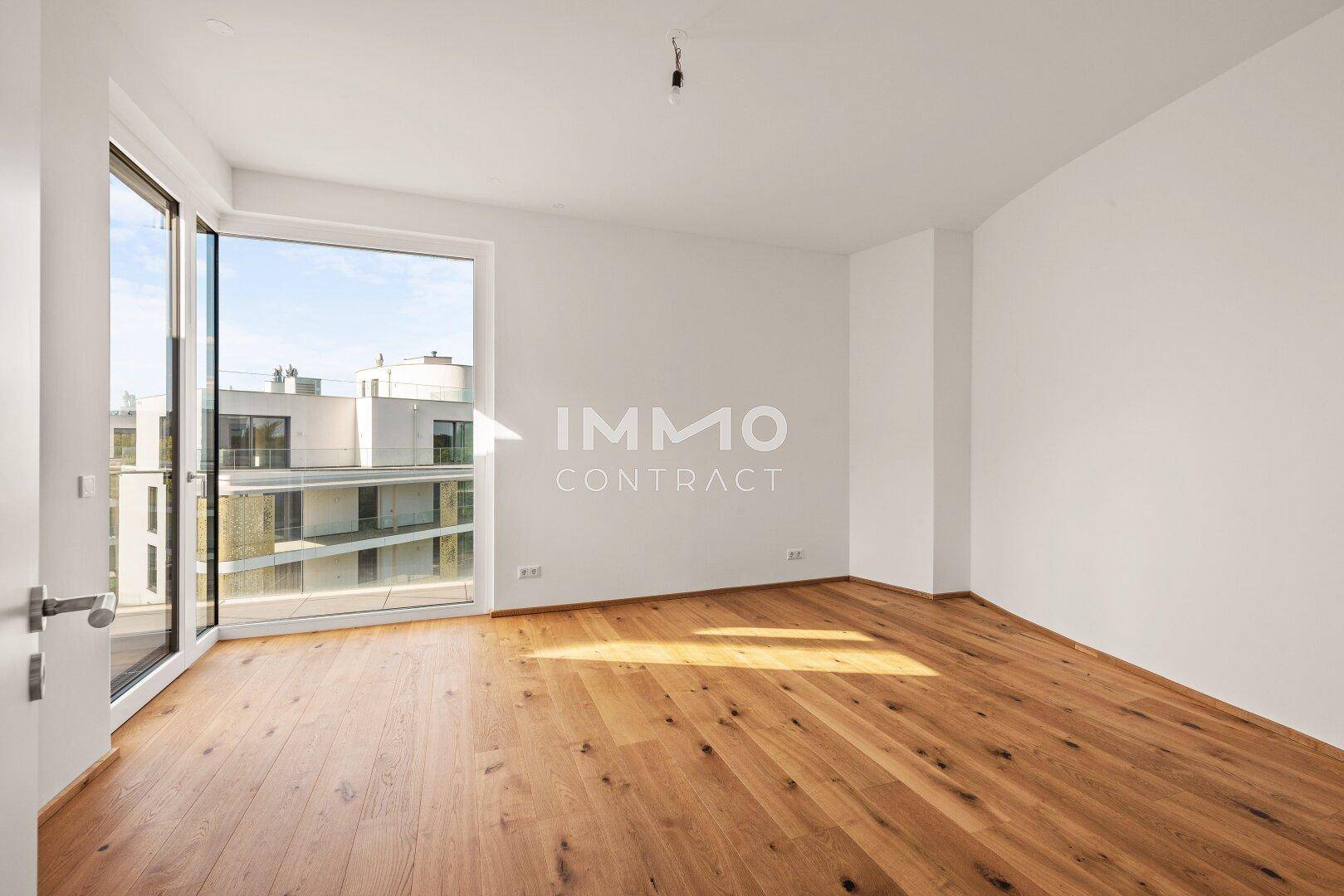 Modernes Schlafzimmer mit Parkettboden und bodentiefen Fenstern, die viel Tageslicht hereinlassen.