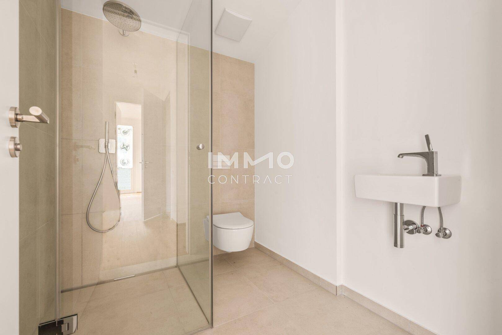 Modernes Badezimmer mit begehbarer Dusche, Wand-WC und eleganten Fliesen in neutralen Farben.