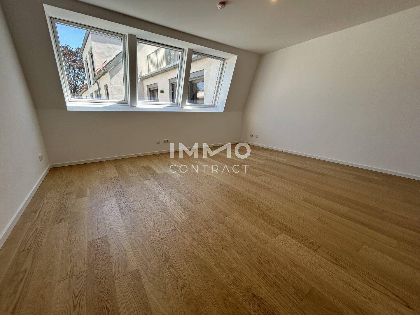Helles Zimmer mit Holzboden und großen Dachfenstern, ideal als Schlaf- oder Arbeitszimmer.