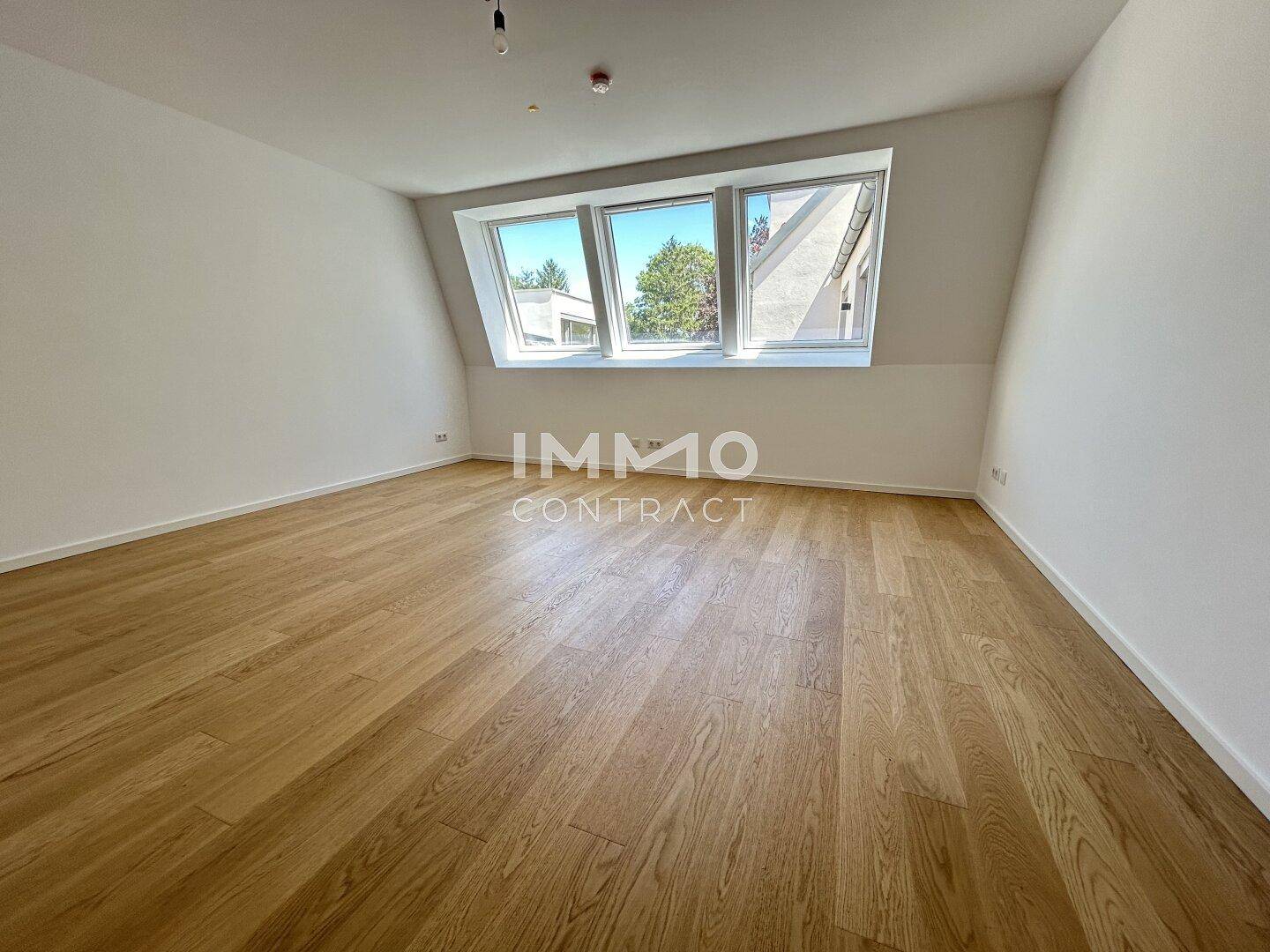 Helles Zimmer mit Holzboden und großen Dachfenstern, ideal als Schlaf- oder Arbeitszimmer.