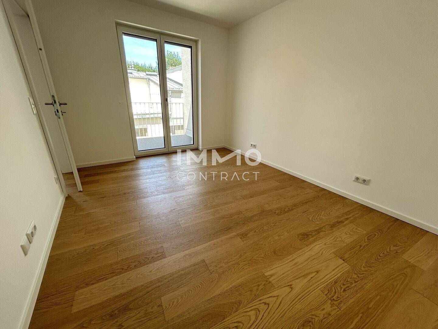 Helles Zimmer mit Holzboden und Balkonzugang, ideal als Schlaf- oder Kinderzimmer.