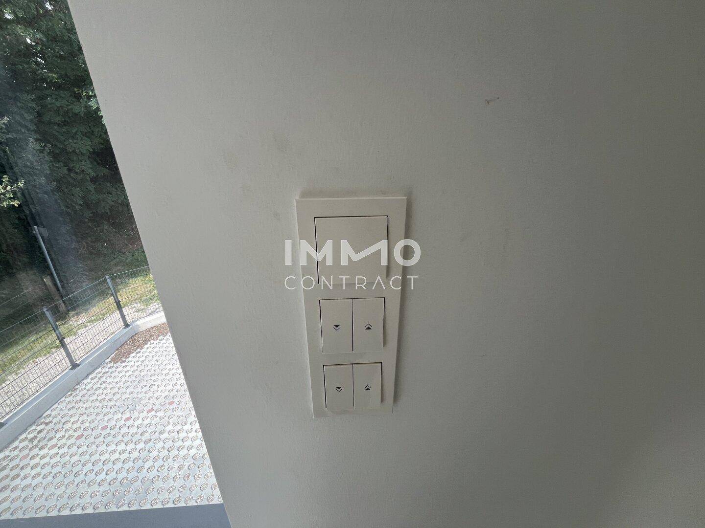 Detailaufnahme von modernen Lichtschaltern an einer weißen Wand in einem neu gebauten Innenraum.