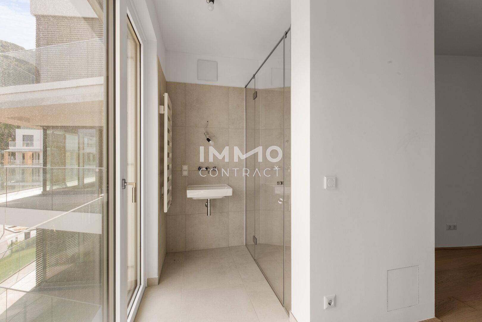 Modernes Badezimmer mit begehbarer Dusche und Waschtisch, direktem Zugang zum Außenbereich.