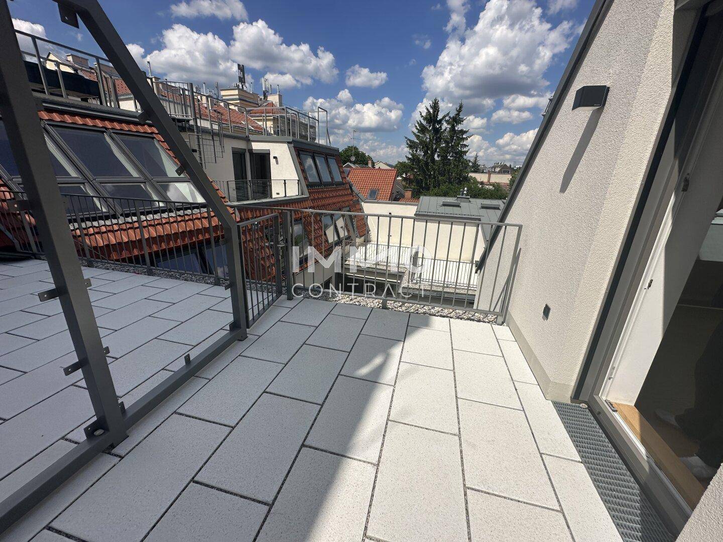 Geräumige Dachterrasse mit Fliesenboden und Blick auf die umliegenden Gebäude, bietet viel Platz.