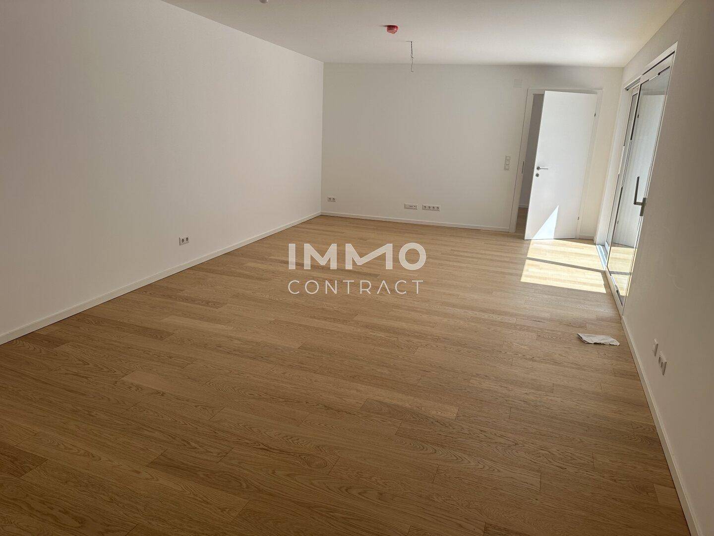 Leeres, helles Wohnzimmer mit Holzboden und großzügigem Raumgefühl, bereit für individuelle Einrichtung.