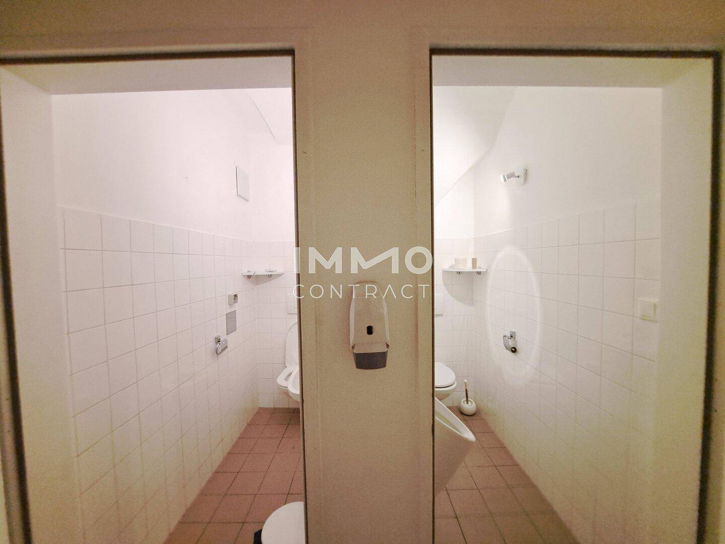 Zwei separate Toilettenräume mit weißen Fliesen und funktionaler Ausstattung, sauber und gepflegt.