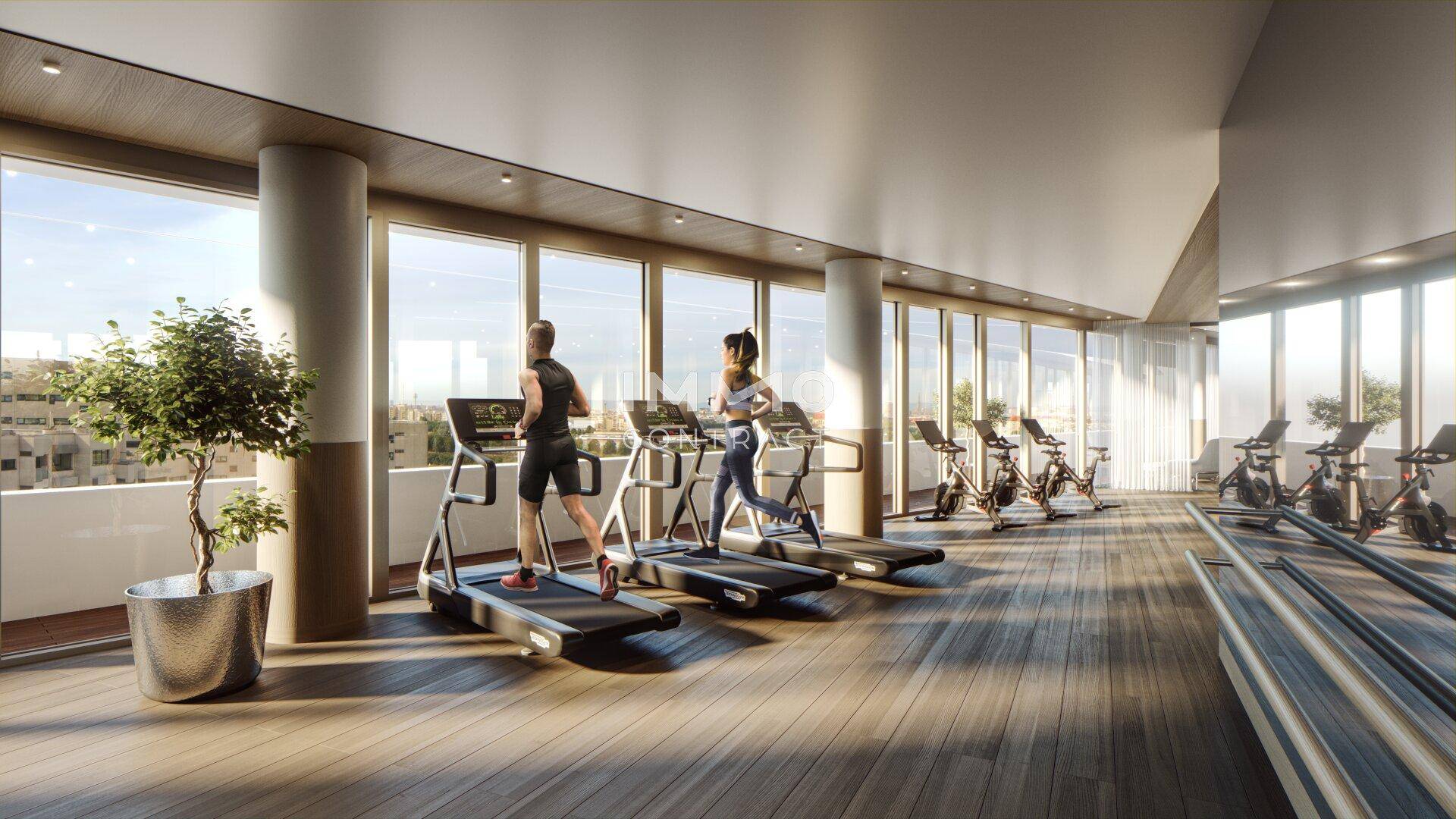 Helles Fitnessstudio mit modernen Geräten, Holzboden und großen Fenstern mit Stadtblick.