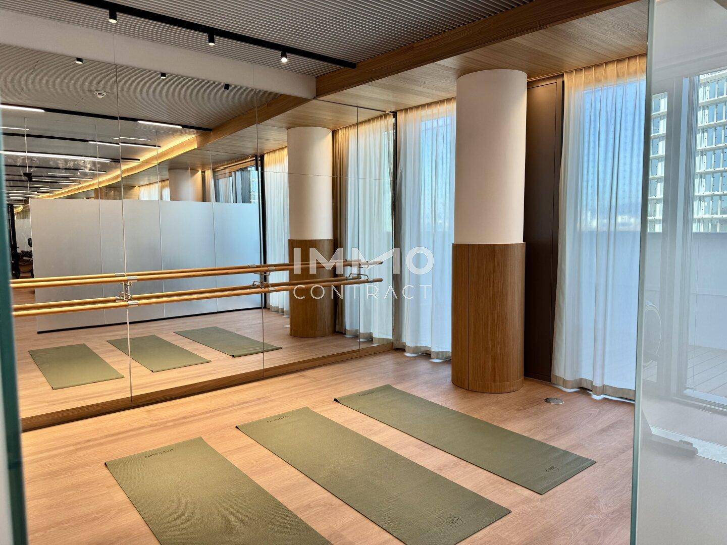 Bereich für Yoga oder Tanz mit Spiegelwand, Ballettstange und Matten.