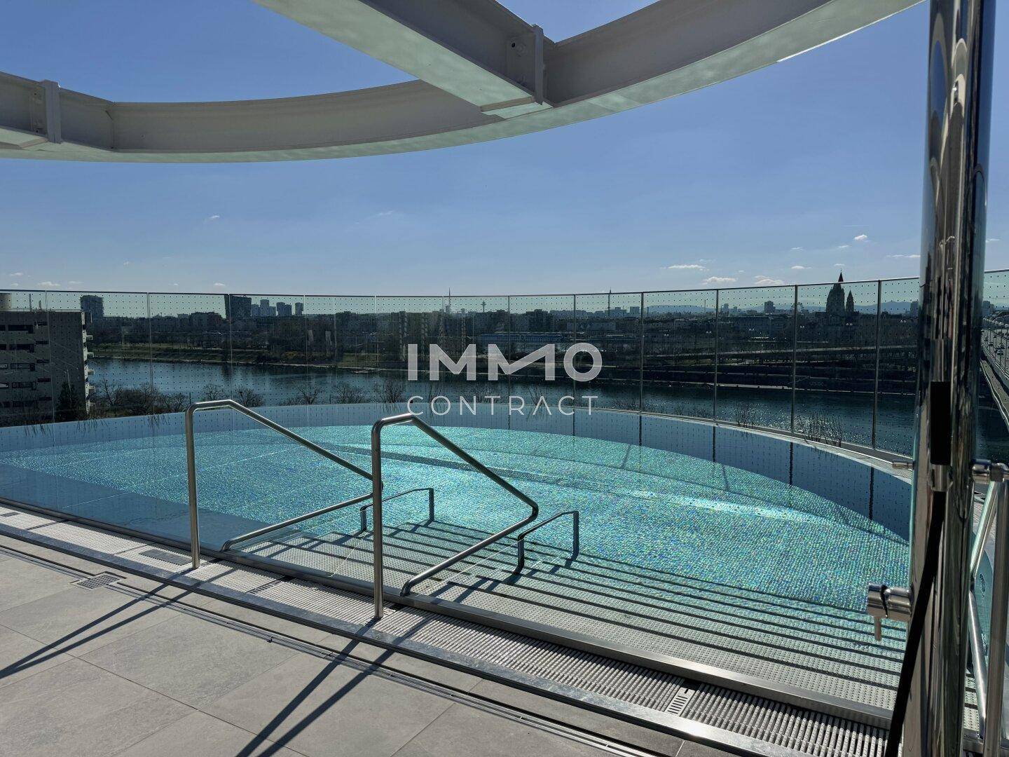 Dachpool mit Panoramablick auf die Stadt und den Fluss, umgeben von einer Glasbrüstung.