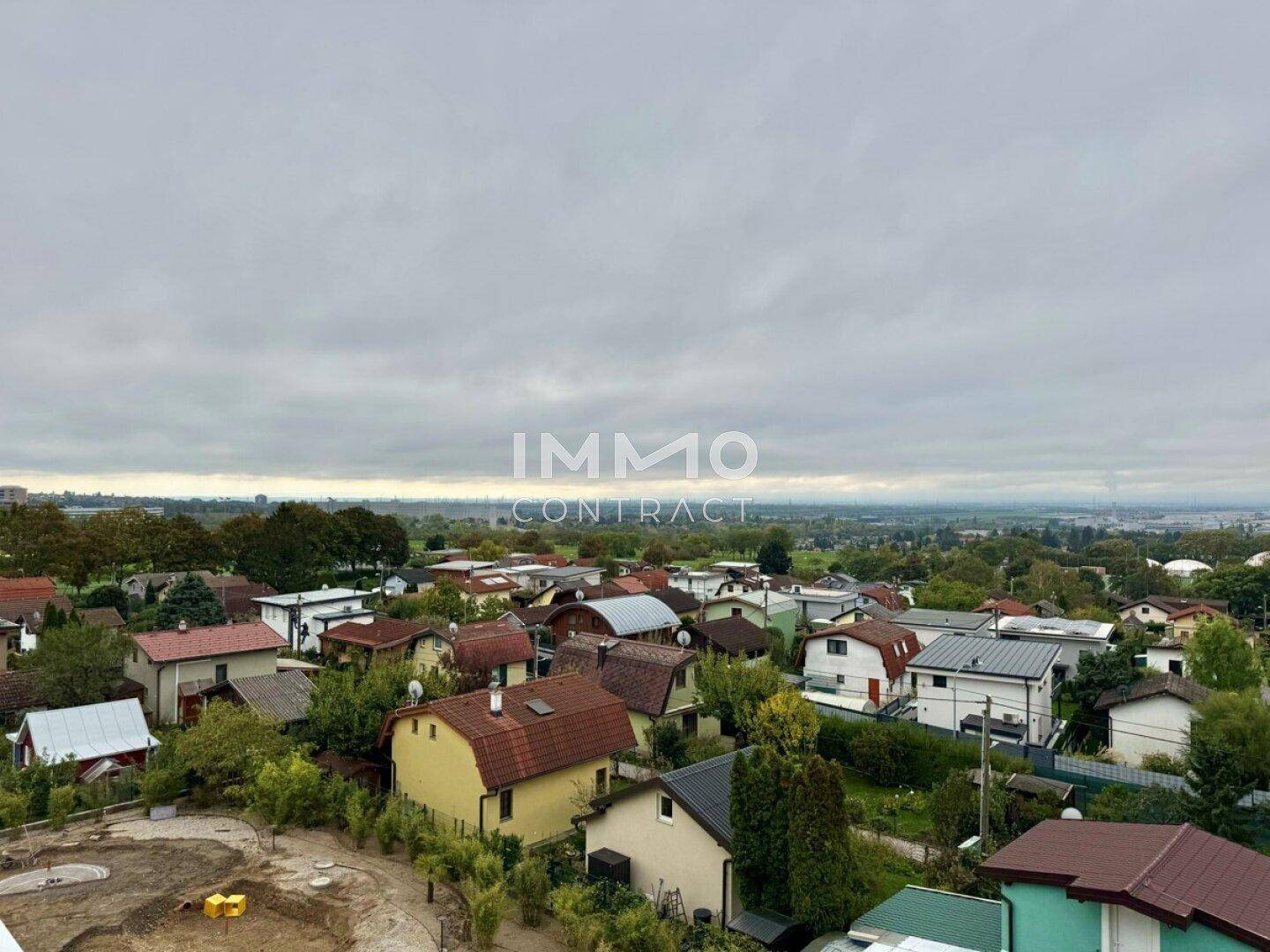 Weitläufiger Blick über die umliegende Wohnsiedlung und Landschaft unter bewölktem Himmel.