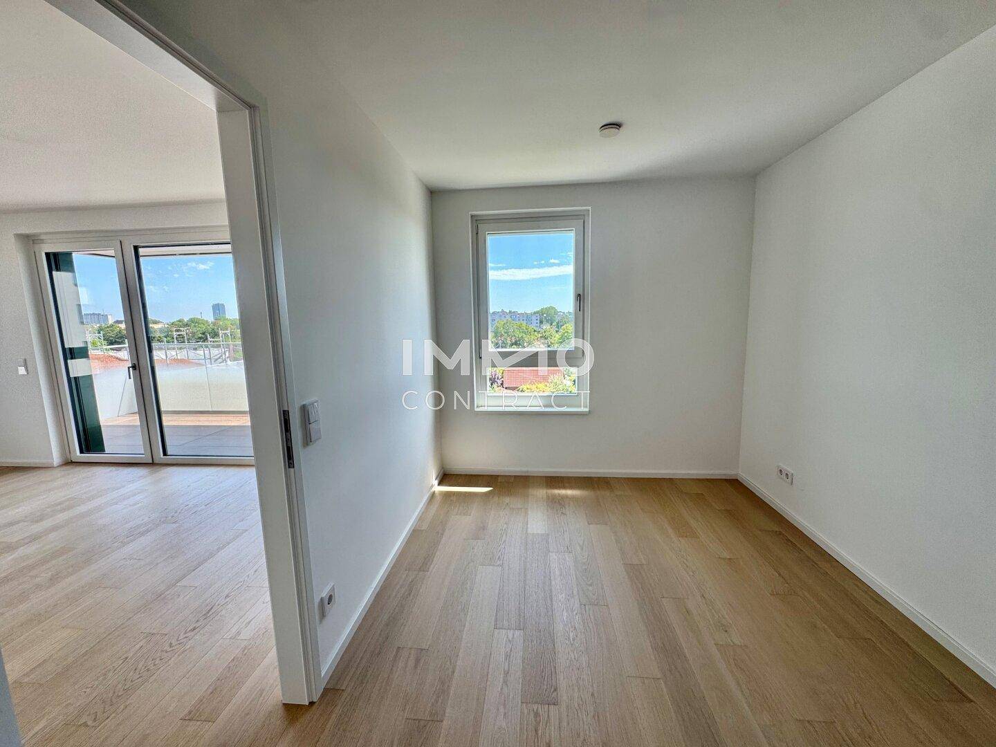 Leerer Raum mit Holzboden und Zugang zu einem Balkon, ideal für individuelle Gestaltung.