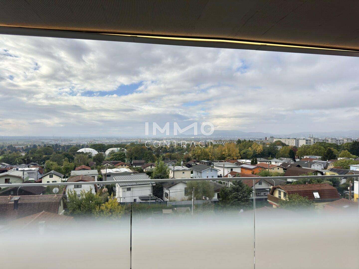 Breiter Balkon mit Panoramablick über die Dächer der Stadt und die umliegende Landschaft.
