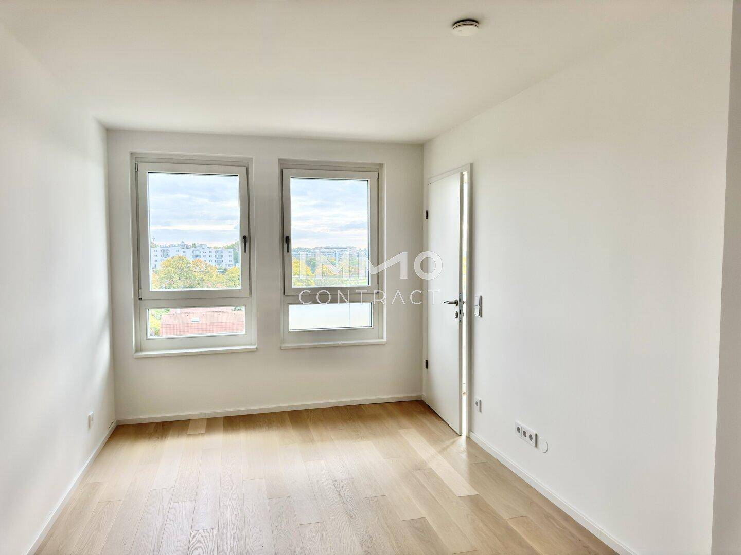 Helles Zimmer mit Parkettboden und zwei großen Fenstern, ideal als Schlaf- oder Arbeitszimmer.