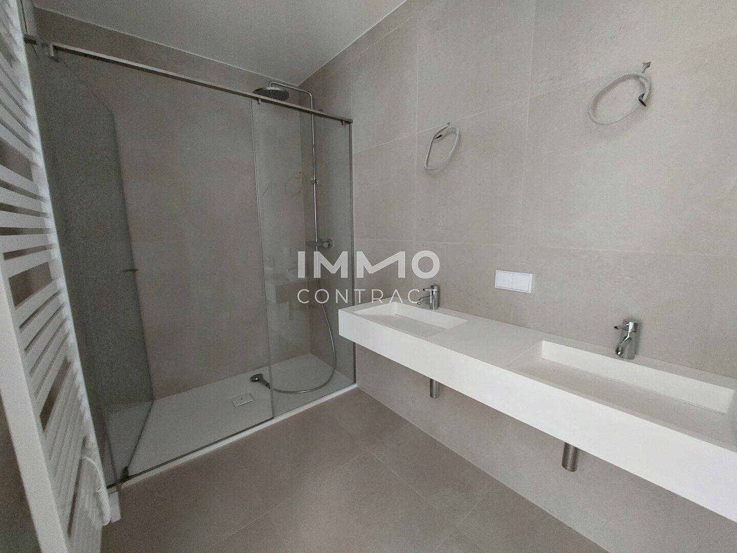 Helles Badezimmer mit begehbarer Dusche, Doppelwaschbecken und modernem Design.