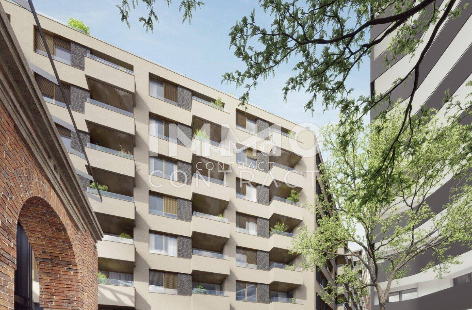 Detailansicht der modernen Fassade mit versetzten Balkonen und großen Fenstern, umgeben von Bäumen.