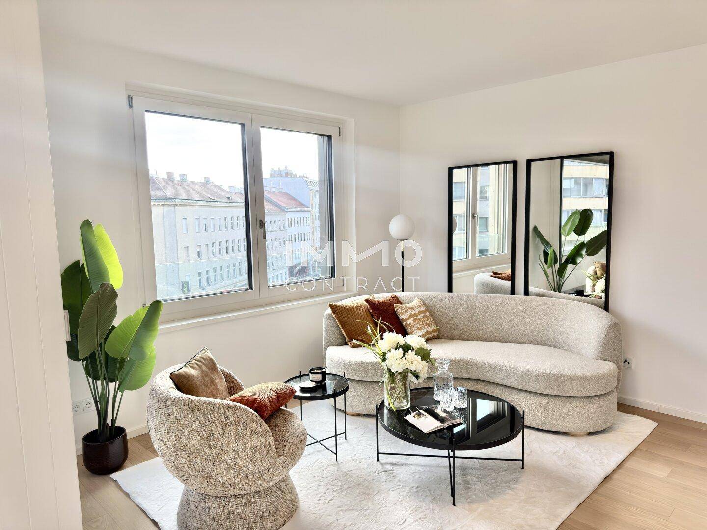 Gemütliches Wohnzimmer mit bequemer Couch, großen Fenstern und Blick auf die Stadt.