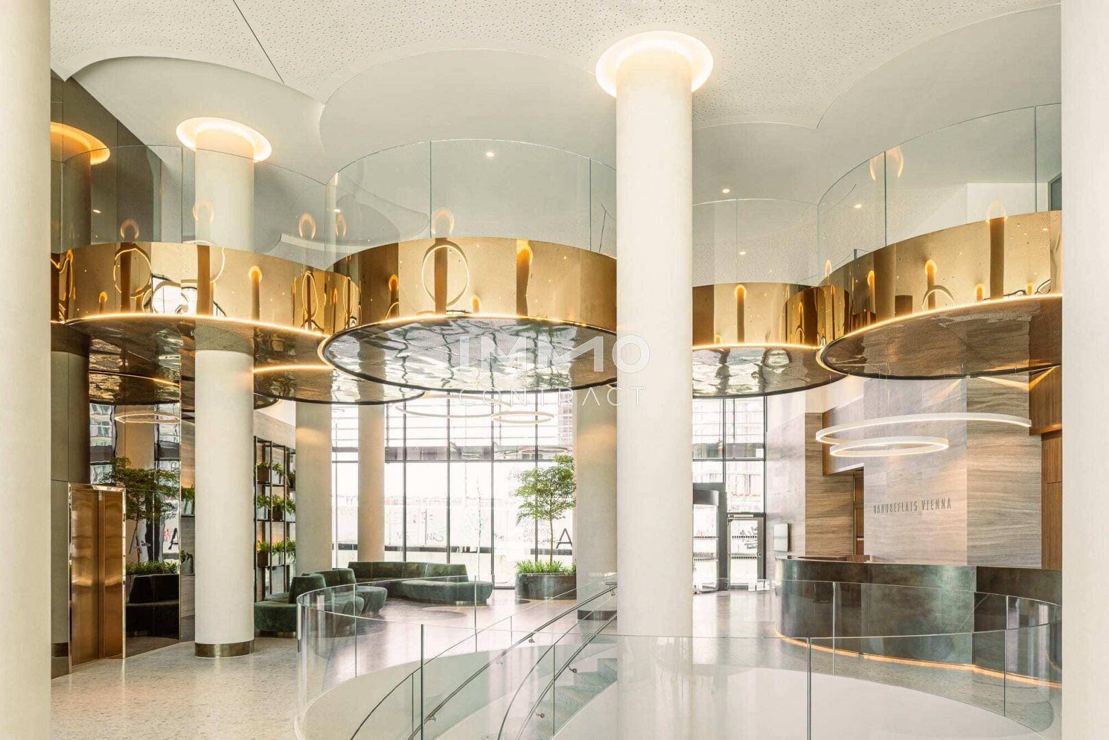 Luxuriöse Lobby mit hohen Säulen, modernen Leuchten und eleganten Sitzbereichen.