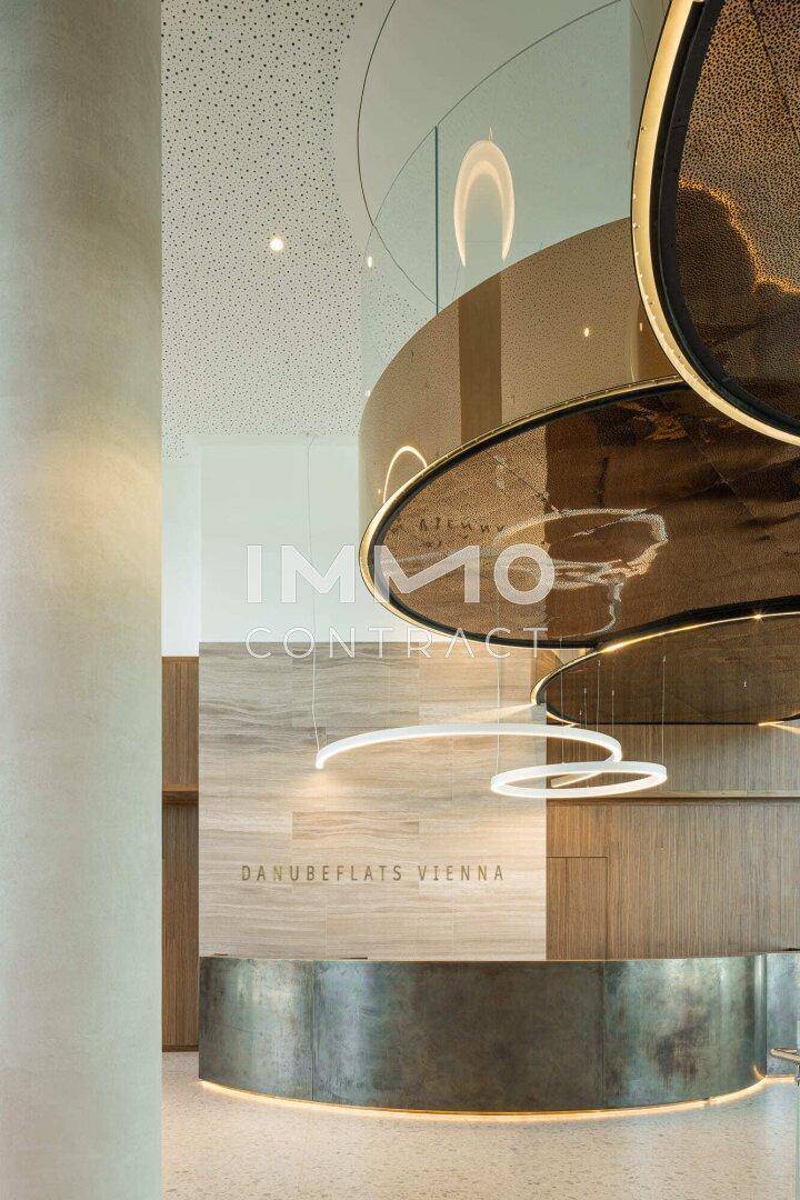 Detailansicht der modernen Lobby mit stilvoller Rezeption und dekorativen Beleuchtungselementen.
