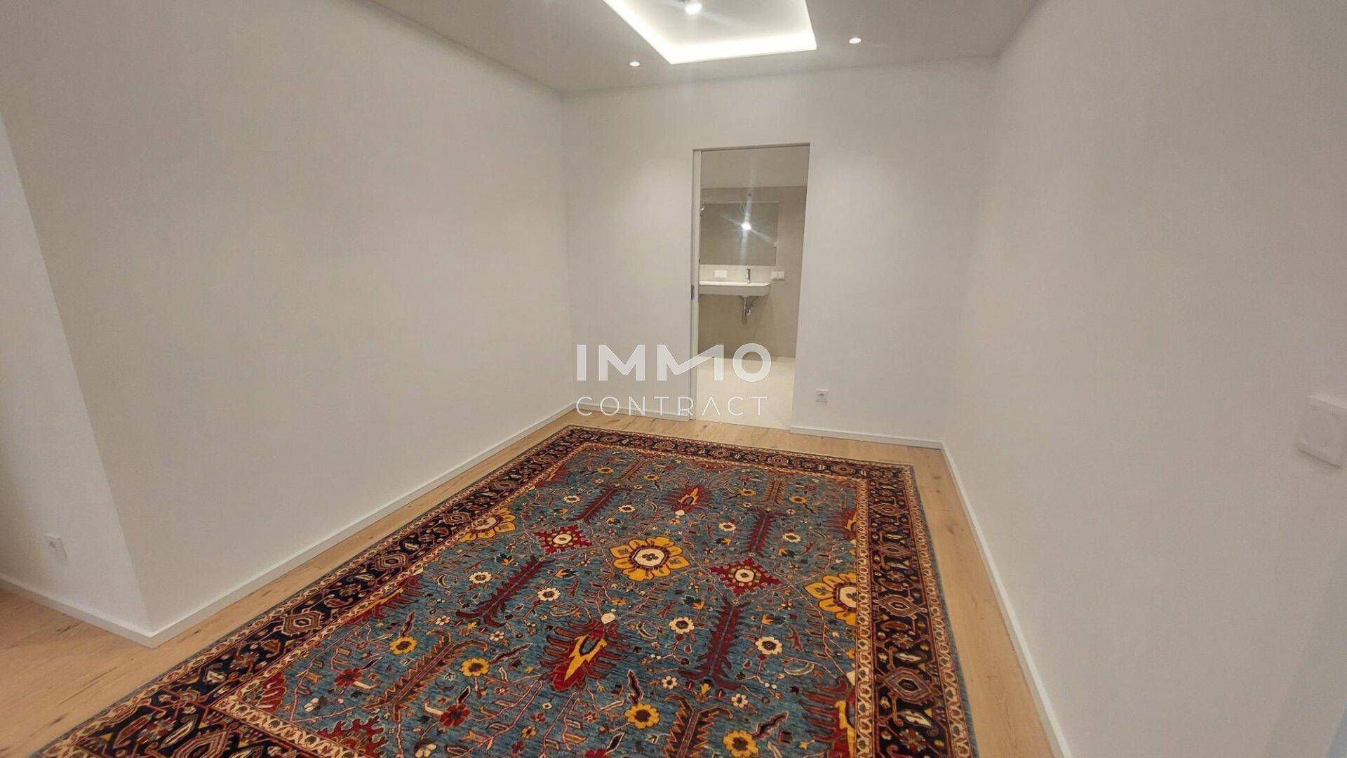 Gemütliches Schlafzimmer mit Holzboden und direktem Zugang zu einem modernen Badezimmer.