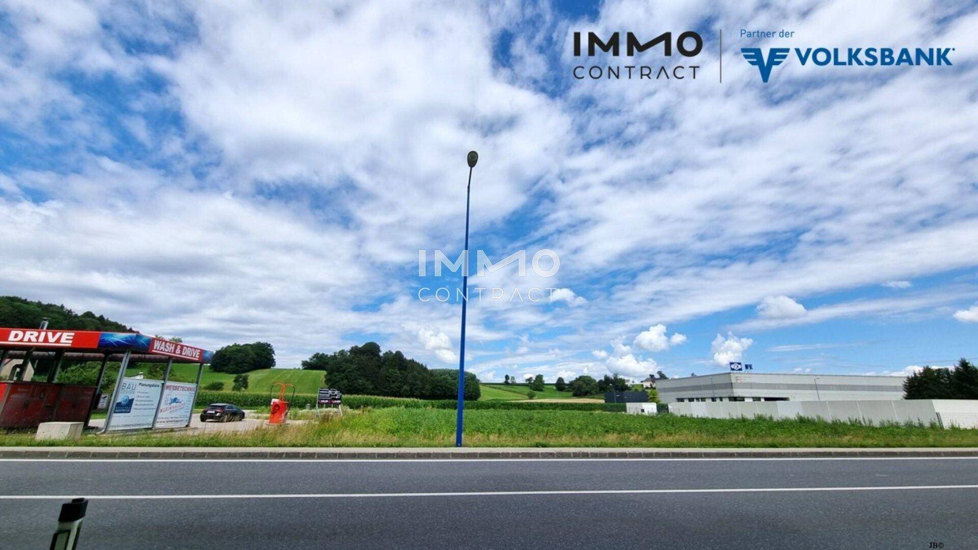 Grünes Grundstück neben einer Autowaschanlage mit weitem Blick auf die Landschaft.