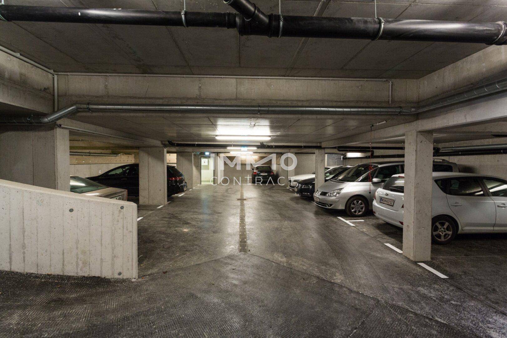 Geräumige Tiefgarage mit Betonwänden und ausreichend Stellplätzen für Fahrzeuge.