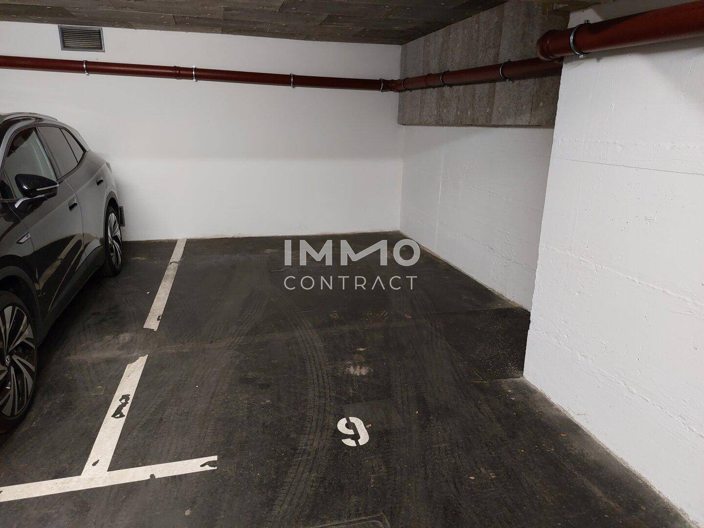 Tiefgarage mit einem dunklen Auto und weiteren Stellplätzen.