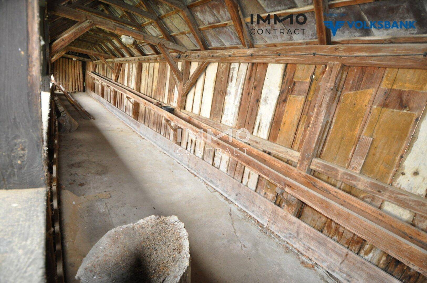 Geräumiger Dachboden mit sichtbaren Holzbalken und Holzverkleidung, ideal als Lagerraum.