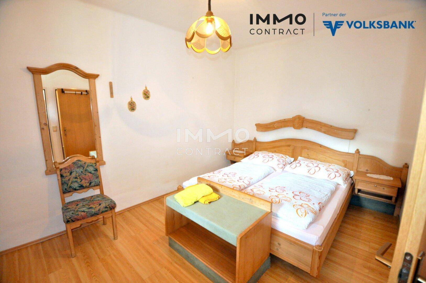 Komfortables Doppelzimmer mit Holzbett, Nachttischen und einem kleinen Beistelltisch.