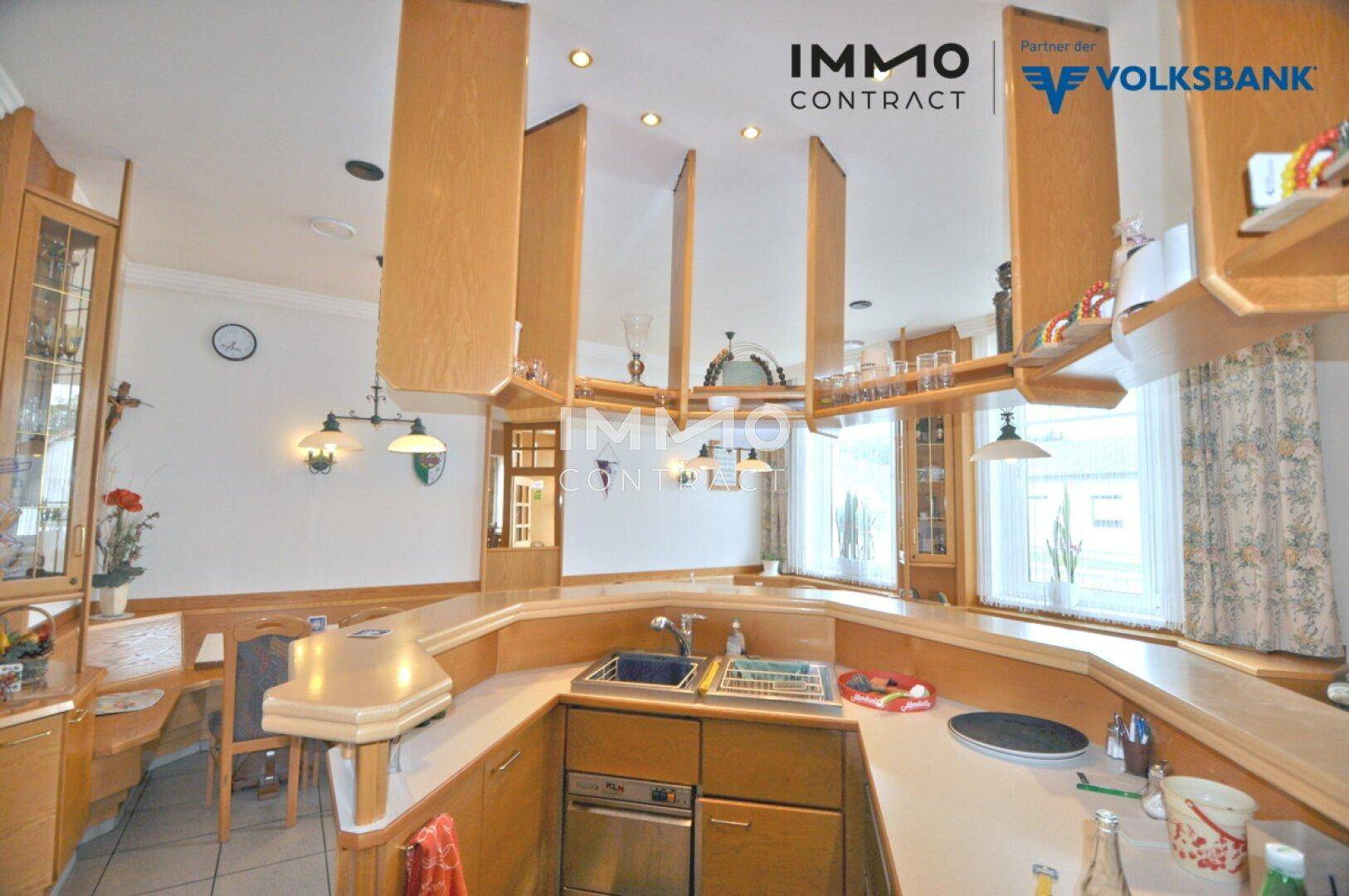 Geräumiger Barbereich mit U-förmiger Theke, Holzregalen und Blick nach draußen.