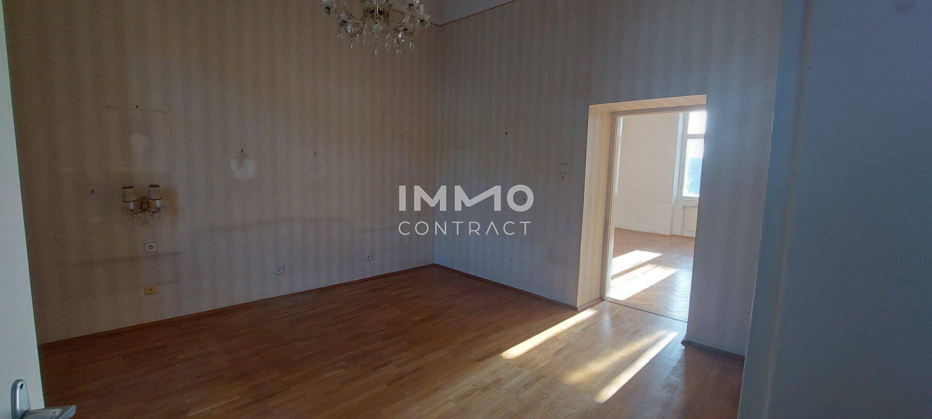 Geräumiges Zimmer mit Parkettboden und Kronleuchter, bereit für eine individuelle Gestaltung.