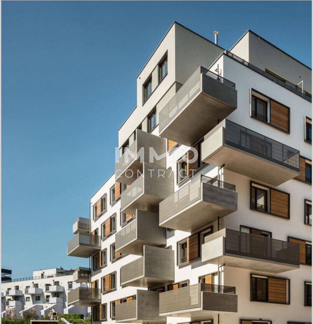Moderne Wohnanlage mit markanten Balkonen und zeitgenössischer Architektur unter blauem Himmel.