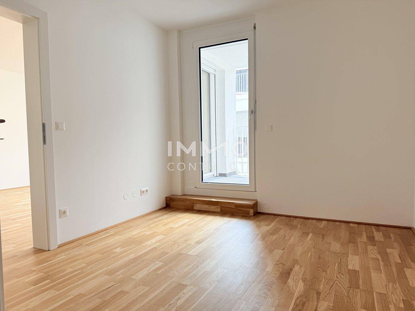 Helles Schlafzimmer mit Parkettboden und Zugang zu einem Balkon, bereit zur individuellen Gestaltung.