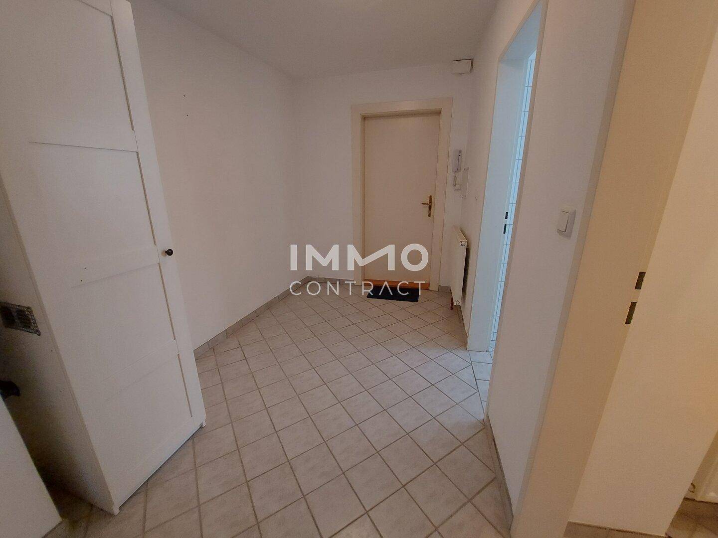 Heller Flur mit Fliesenboden und Zugang zu weiteren Räumen der Wohnung.