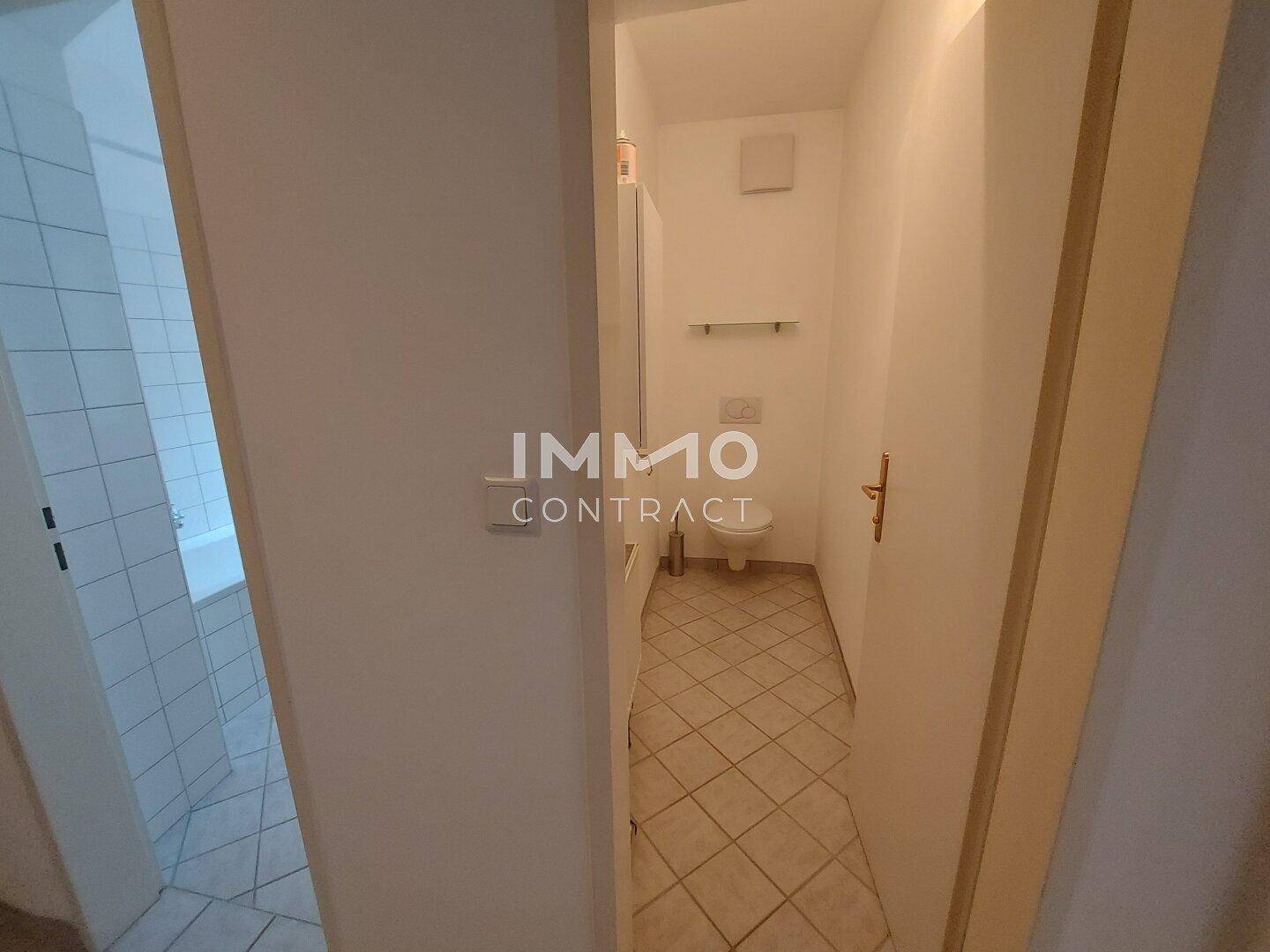 Kleines separates WC mit Fliesenboden und einfacher Ausstattung.