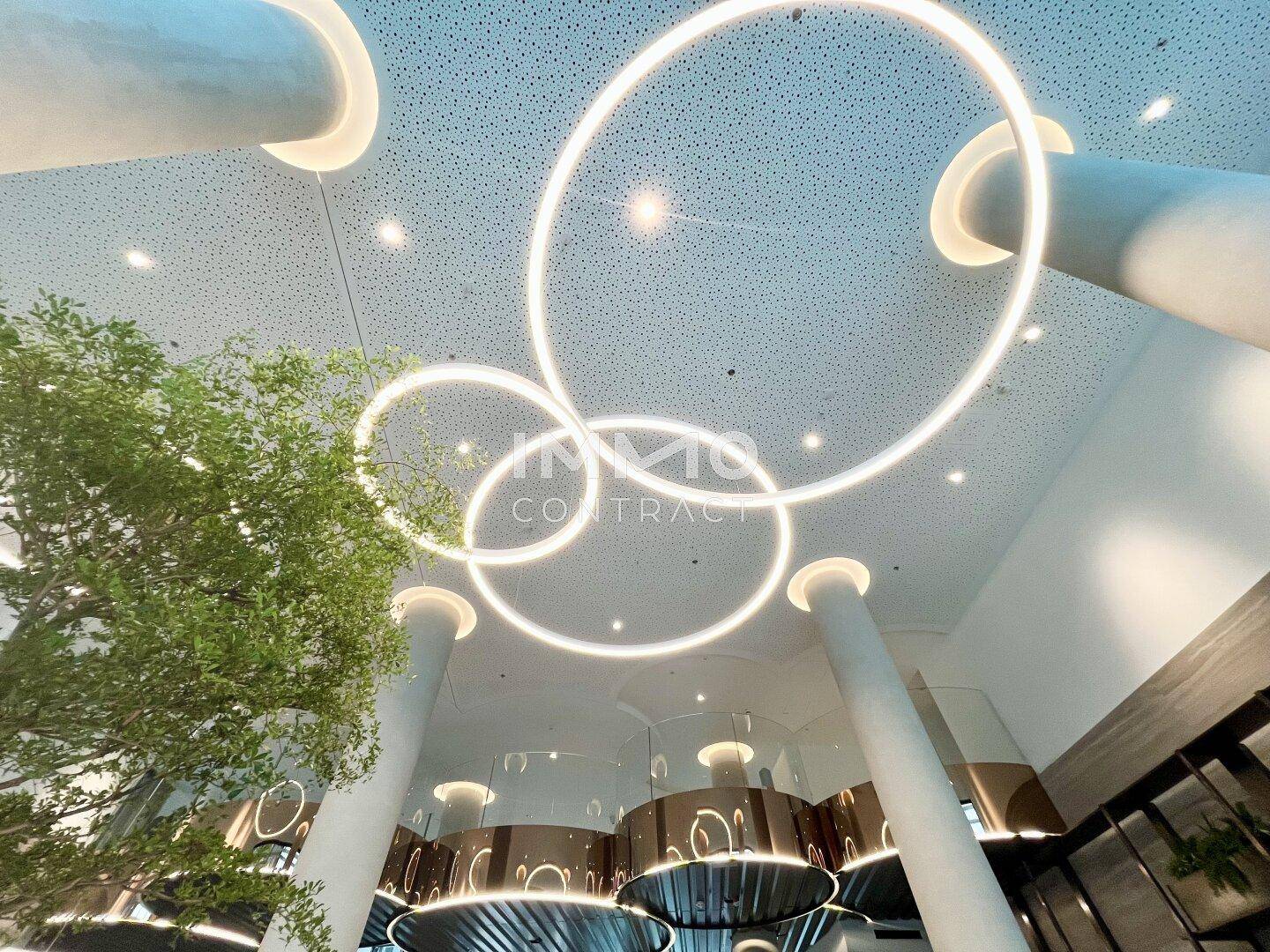 Beeindruckende Deckenbeleuchtung mit runden LED-Elementen in einer modernen Lobby.